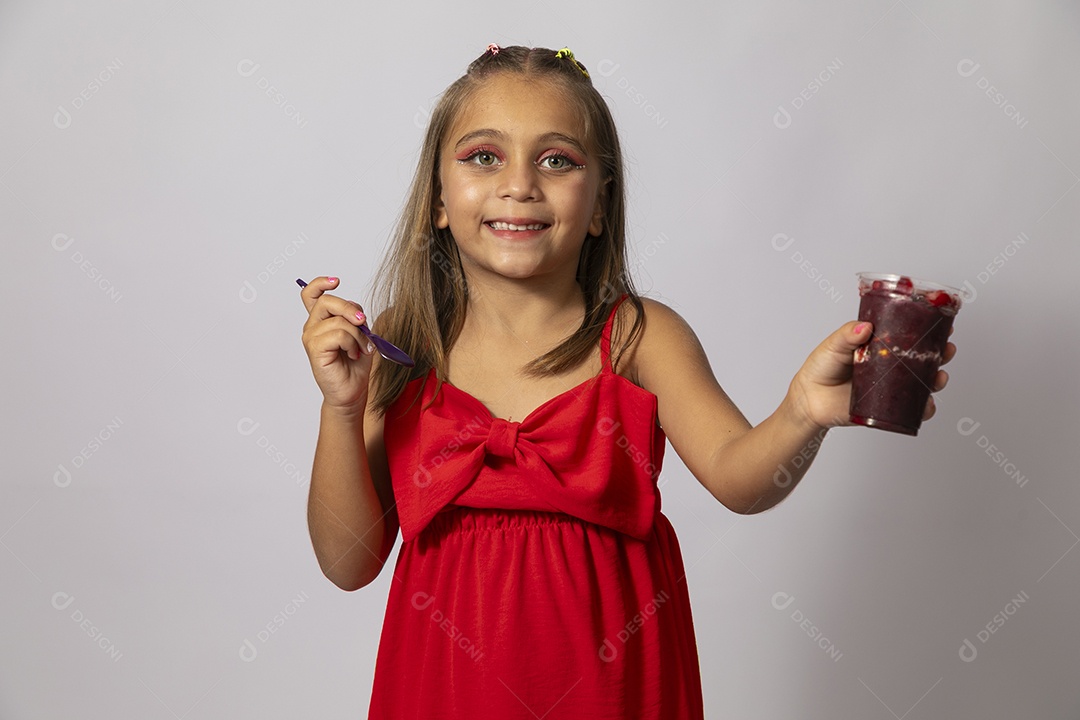Linda menina com look vermelho segurando copo de açai sobre fundo de studio isolado
