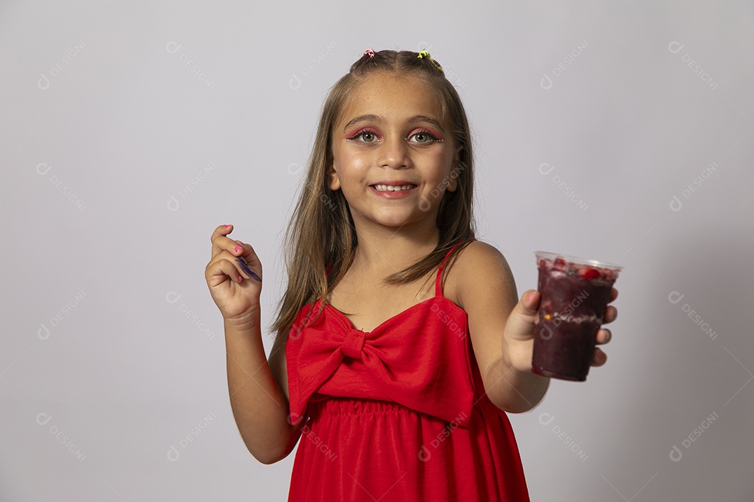 Linda menina com look vermelho segurando copo de açai sobre fundo de studio isolado