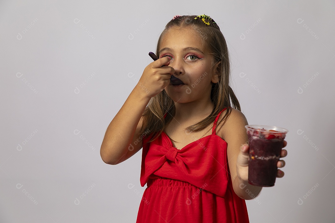Linda menina com look vermelho segurando copo de açai sobre fundo de studio isolado