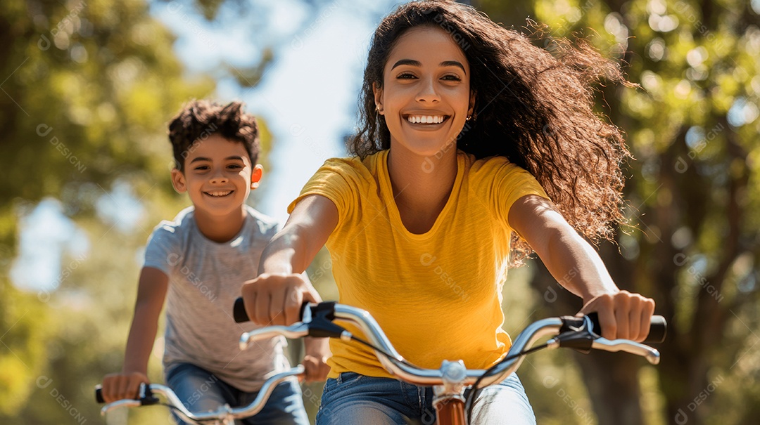 Linda mãe jovem ao lado de seu filho passeando de bicicleta sobre parque