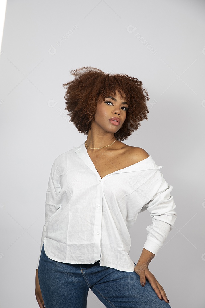 Linda mulher negra de cabelo cacheados fazendo pose sobre fundo branco isolado
