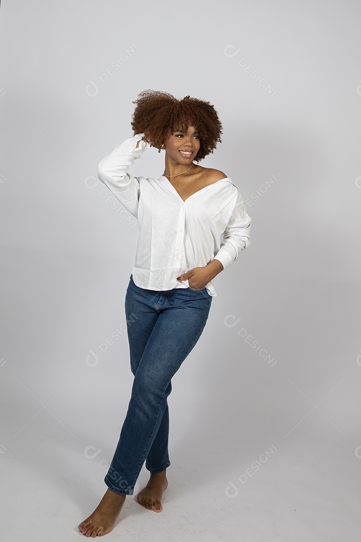 Linda mulher negra de cabelo cacheados fazendo pose sobre fundo branco isolado