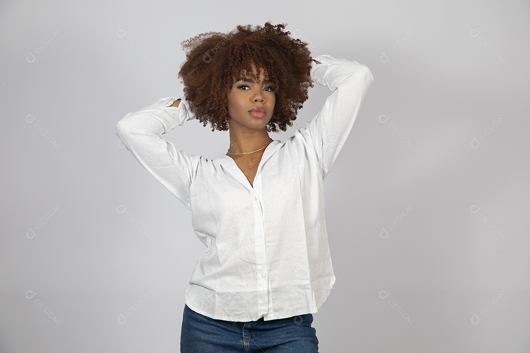 Linda mulher negra de cabelo cacheados fazendo pose sobre fundo branco isolado