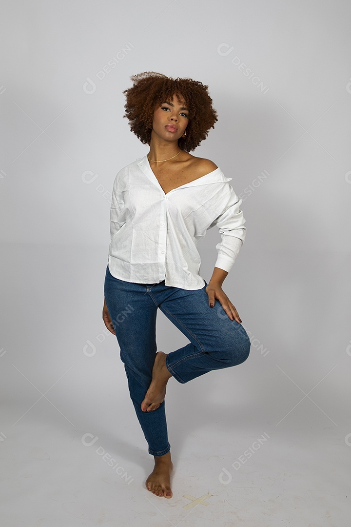 Linda mulher negra de cabelo cacheados fazendo pose sobre fundo branco isolado
