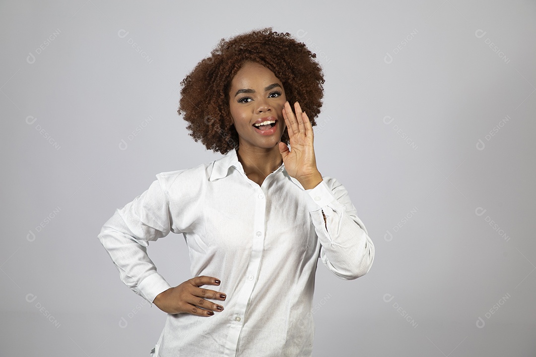 Linda mulher negra de cabelo cacheados fazendo pose sobre fundo branco isolado