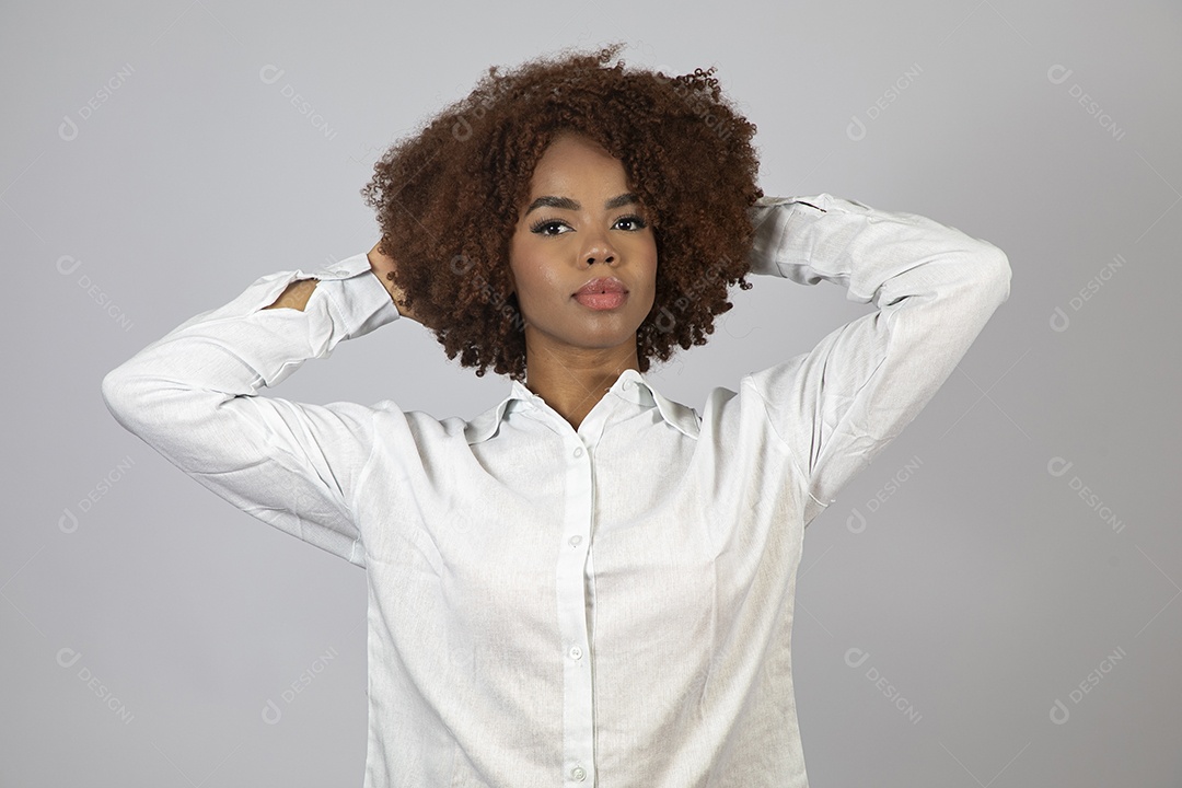 Linda mulher negra de cabelo cacheados fazendo pose sobre fundo branco isolado