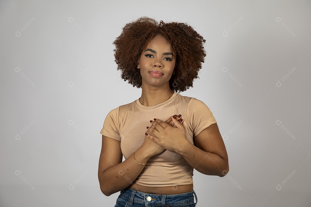 Linda mulher negra de cabelo cacheados fazendo pose sobre fundo branco isolado
