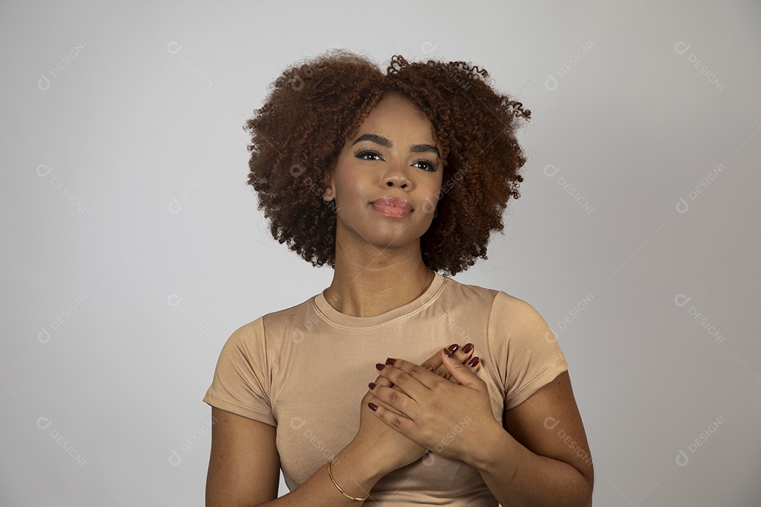 Linda mulher negra de cabelo cacheados fazendo pose sobre fundo branco isolado