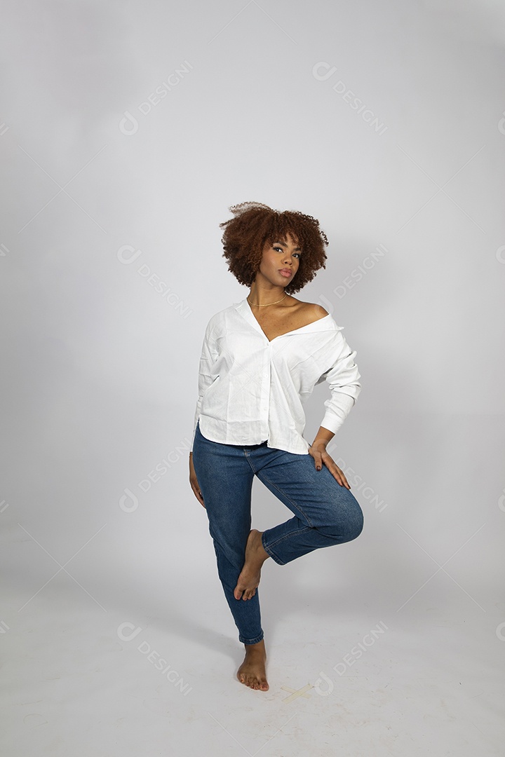 Linda mulher negra de cabelo cacheados fazendo pose sobre fundo branco isolado
