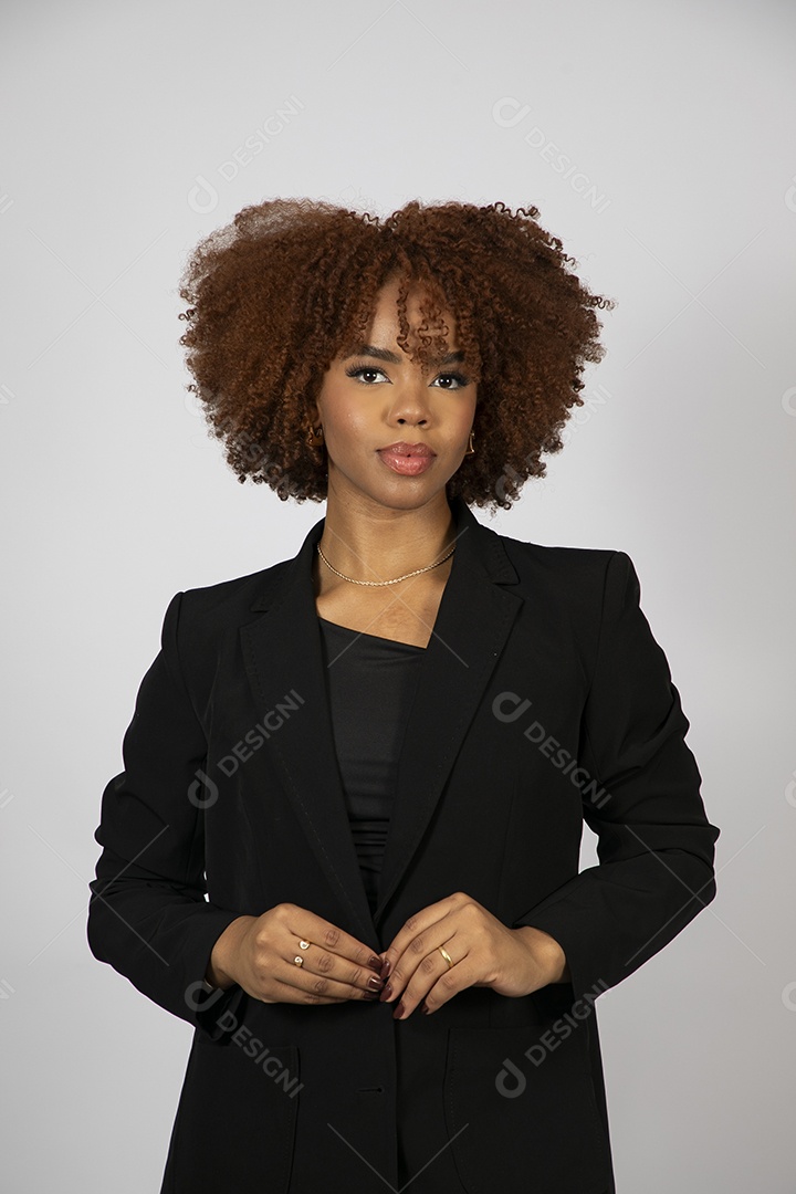 Linda mulher negra de cabelo cacheados usando look preto fazendo pose sobre fundo branco isolado
