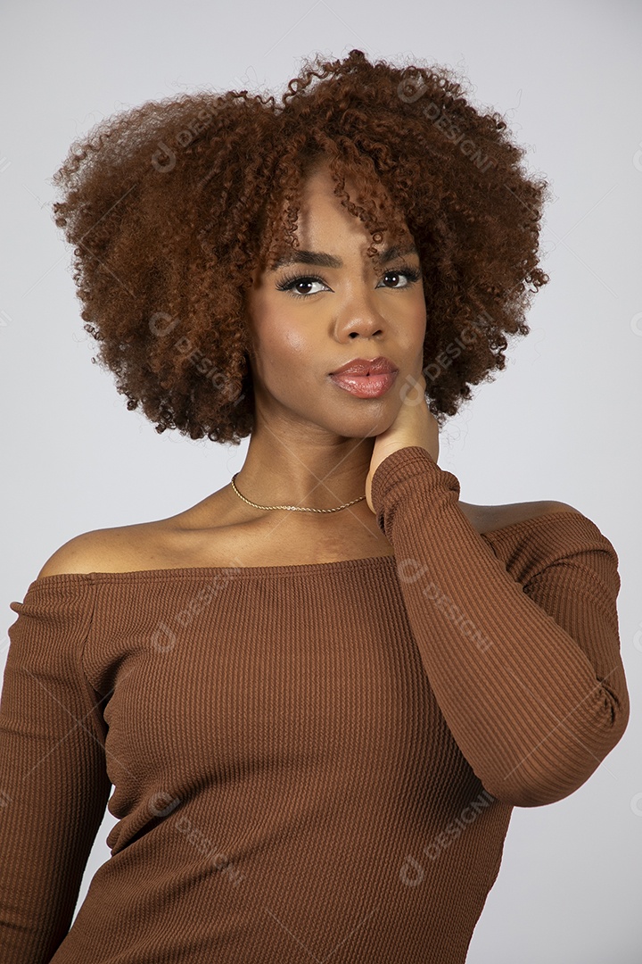 Linda mulher negra de cabelo cacheados usando vestido marrom fazendo pose sobre fundo branco isolado