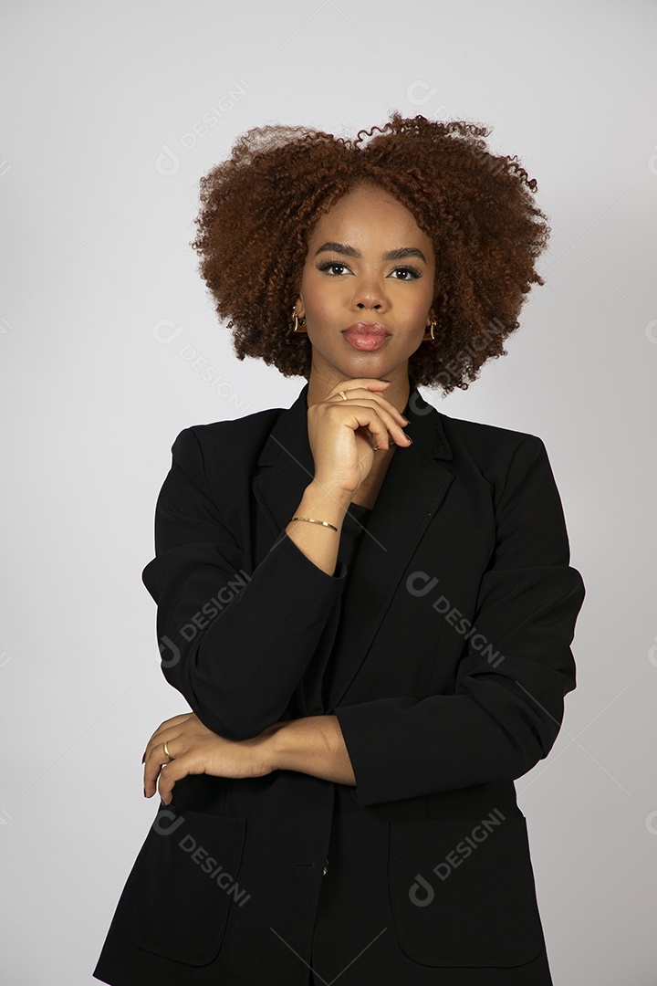 Linda mulher negra de cabelo cacheados usando look preto fazendo pose sobre fundo branco isolado