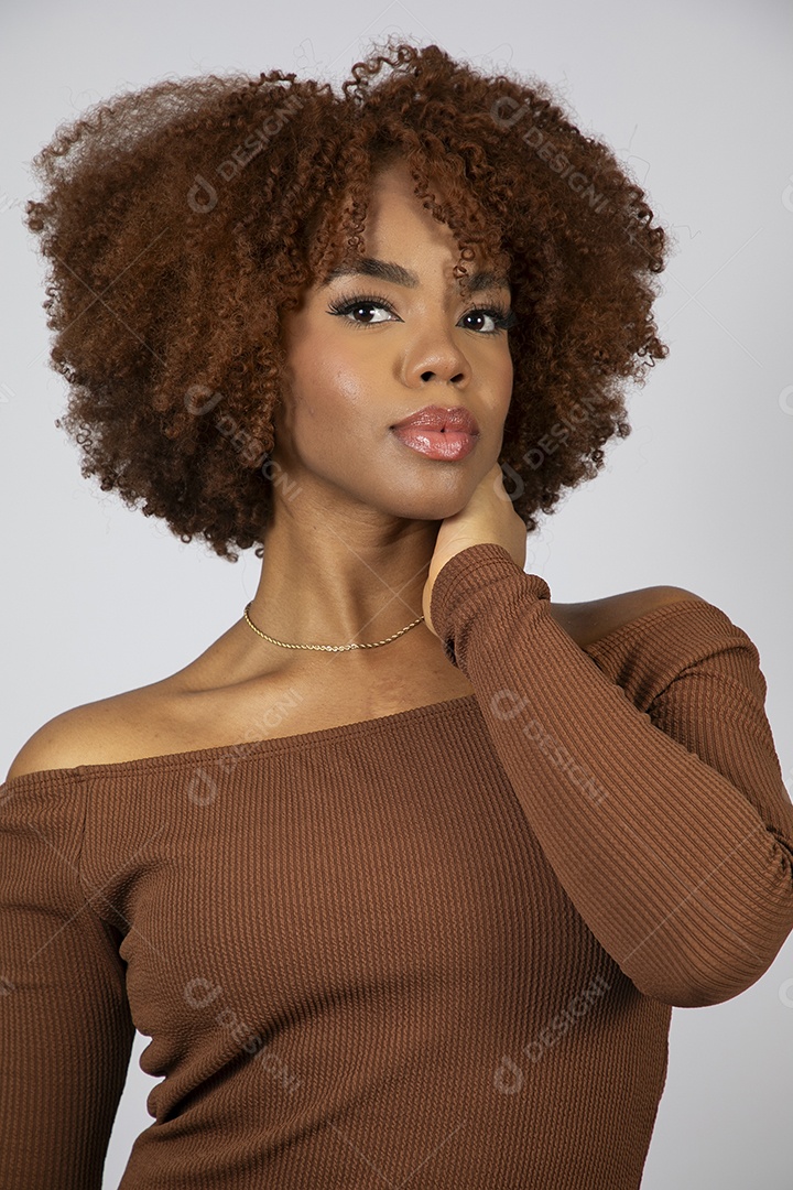 Linda mulher negra de cabelo cacheados usando vestido marrom fazendo pose sobre fundo branco isolado