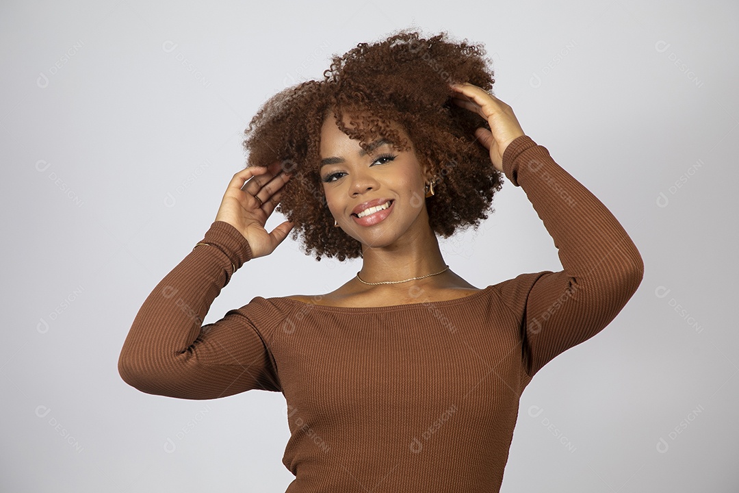 Linda mulher negra de cabelo cacheados usando vestido marrom fazendo pose sobre fundo branco isolado