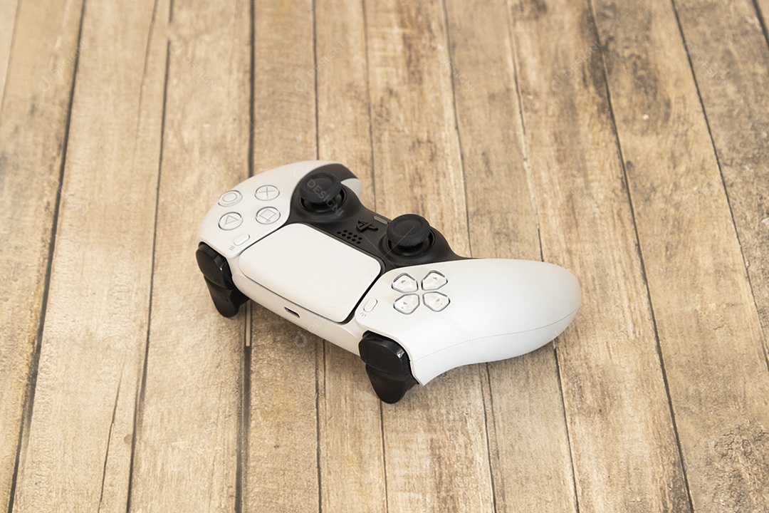 Vista superior de um controle remoto branco do Sony Playstation 5 sobre uma mesa branca