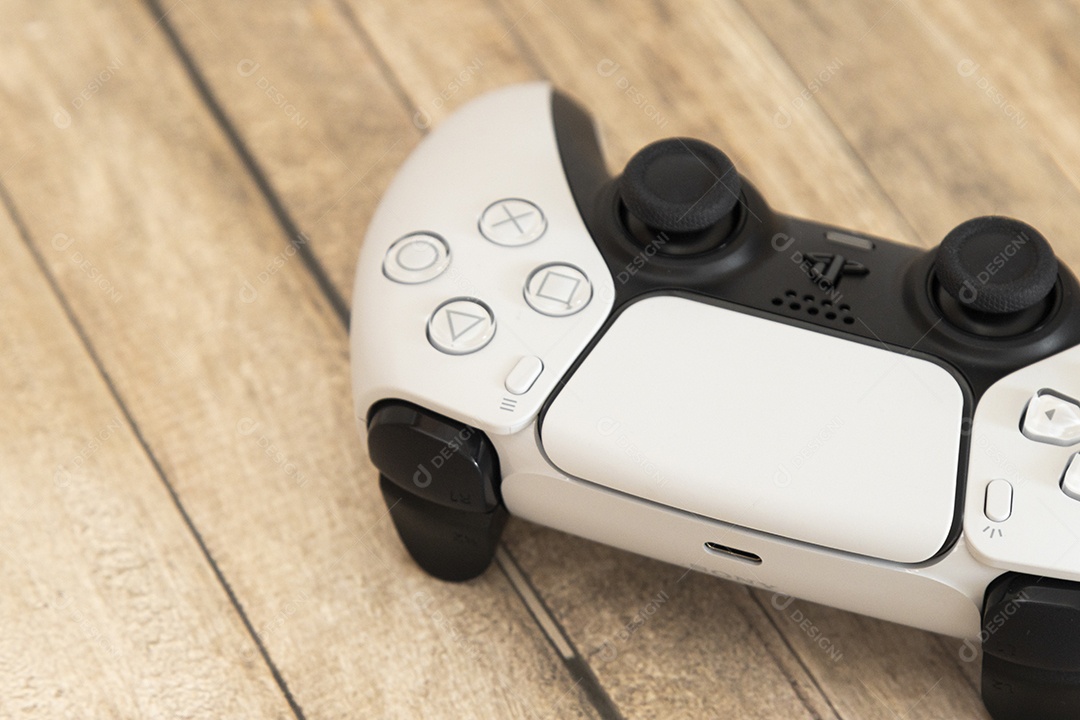 Vista superior de um controle remoto branco do Sony Playstation 5 sobre uma mesa branca