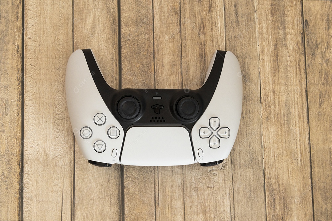 Vista superior de um controle remoto branco do Sony Playstation 5 sobre uma mesa branca