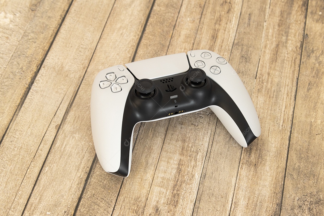 Vista superior de um controle remoto branco do Sony Playstation 5 sobre uma mesa branca