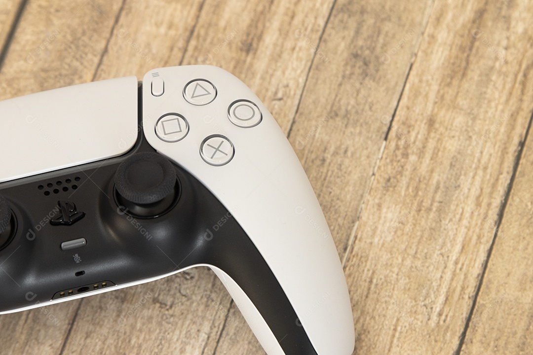 Vista superior de um controle remoto branco do Sony Playstation 5 sobre uma mesa branca