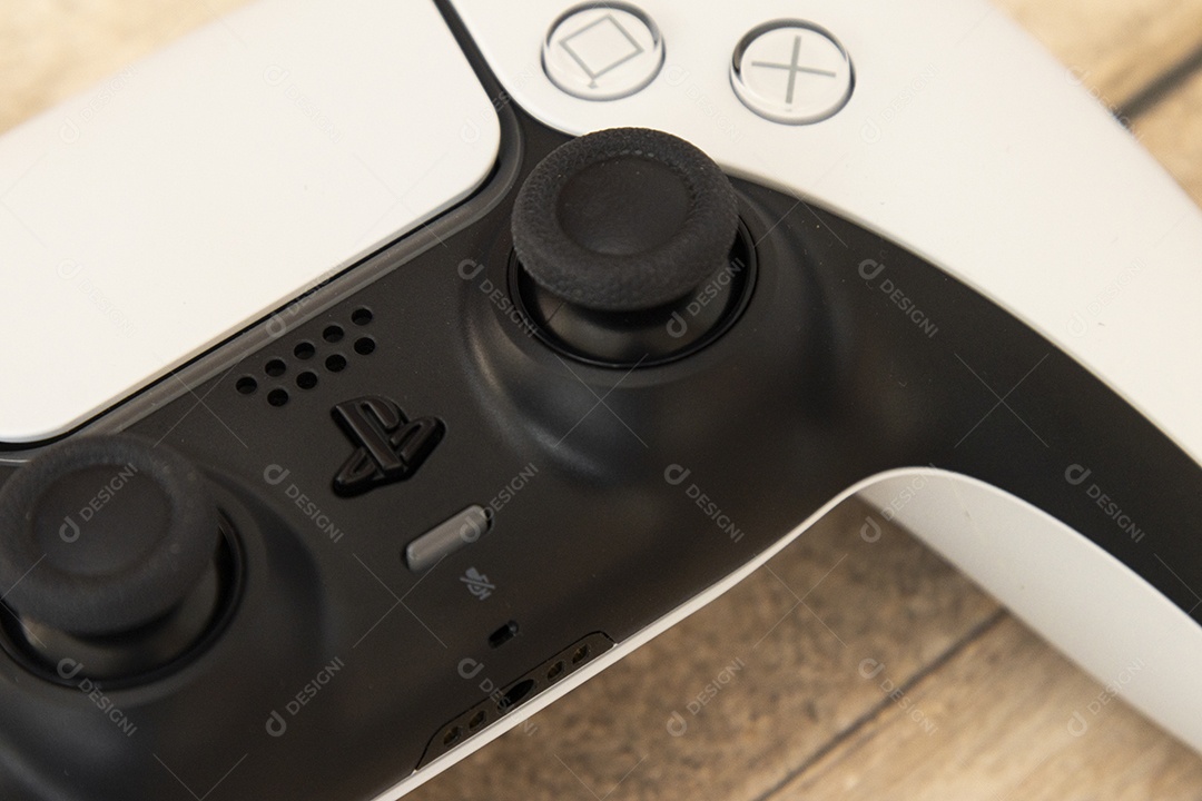 Vista superior de um controle remoto branco do Sony Playstation 5 sobre uma mesa branca