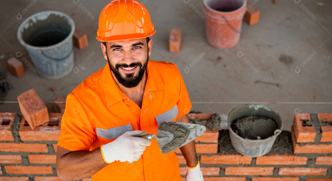 Homem jovem pedreiro sobre obra feliz