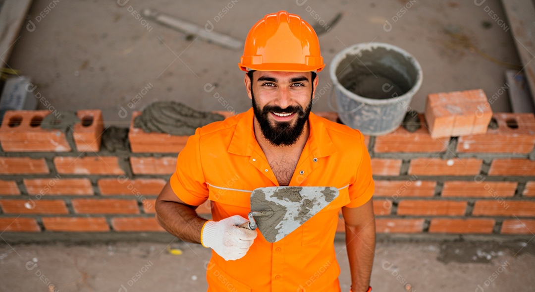 Homem jovem pedreiro sobre obra feliz