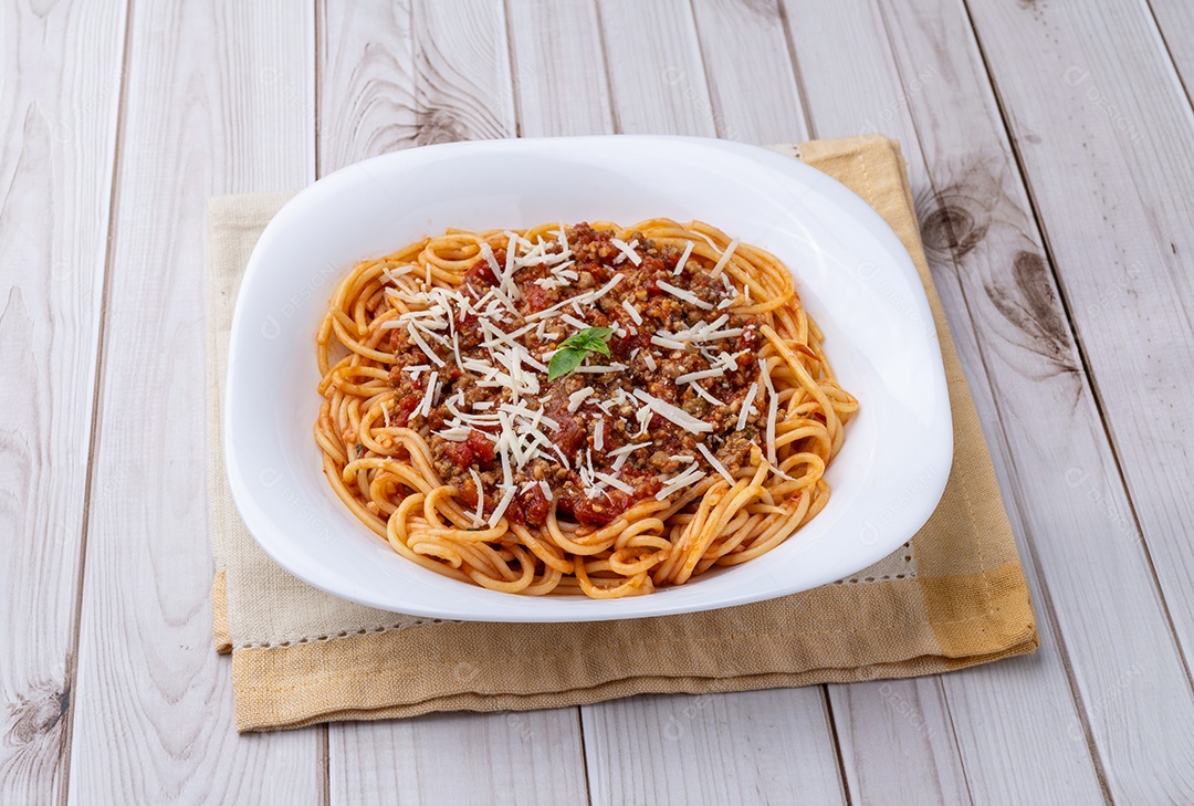 A imagem mostra um prato de espaguete com molho à bolonhesa, um clássico da culinária italiana.