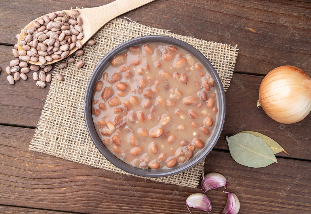 A imagem mostra feijão carioca cozido em uma tigela