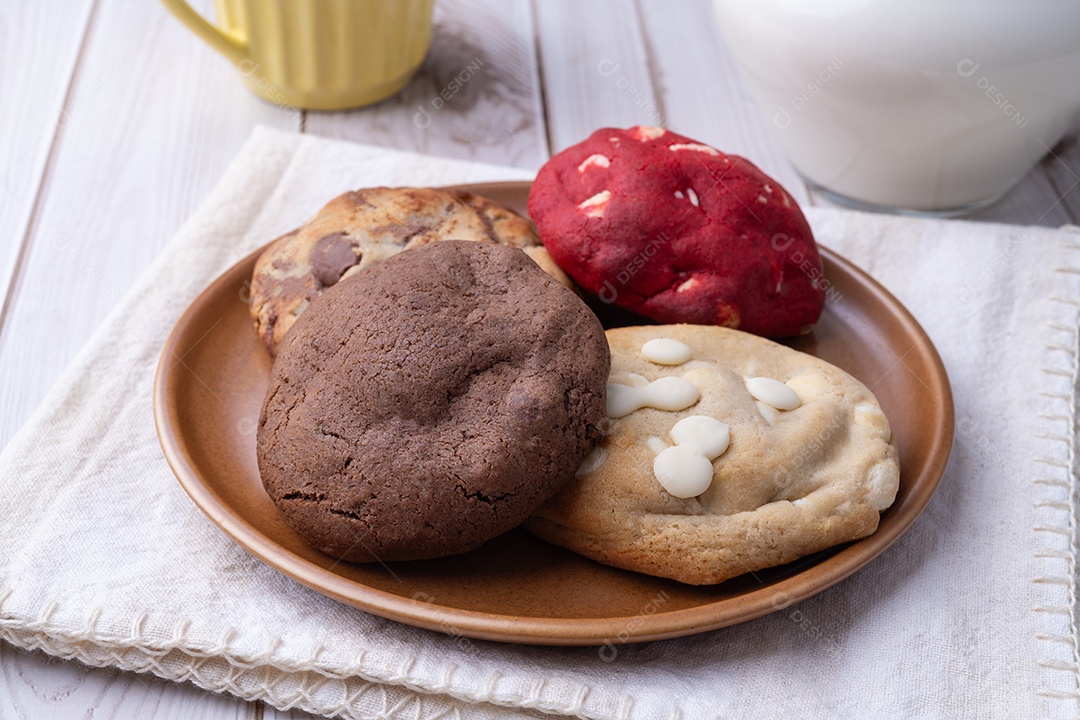A imagem mostra uma variedade de biscoitos (cookies) em um prato de madeira