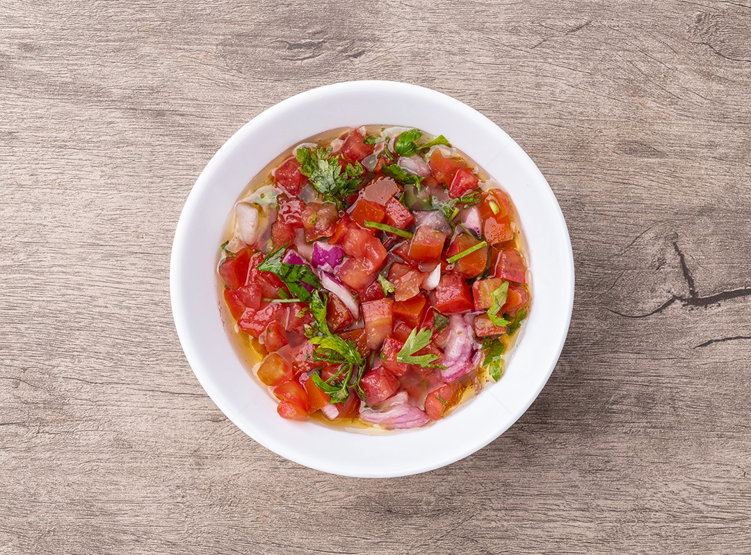A imagem mostra uma tigela de salada de legumes cozidos no vapor, que inclui brócolis, cenoura e couve-flor.
