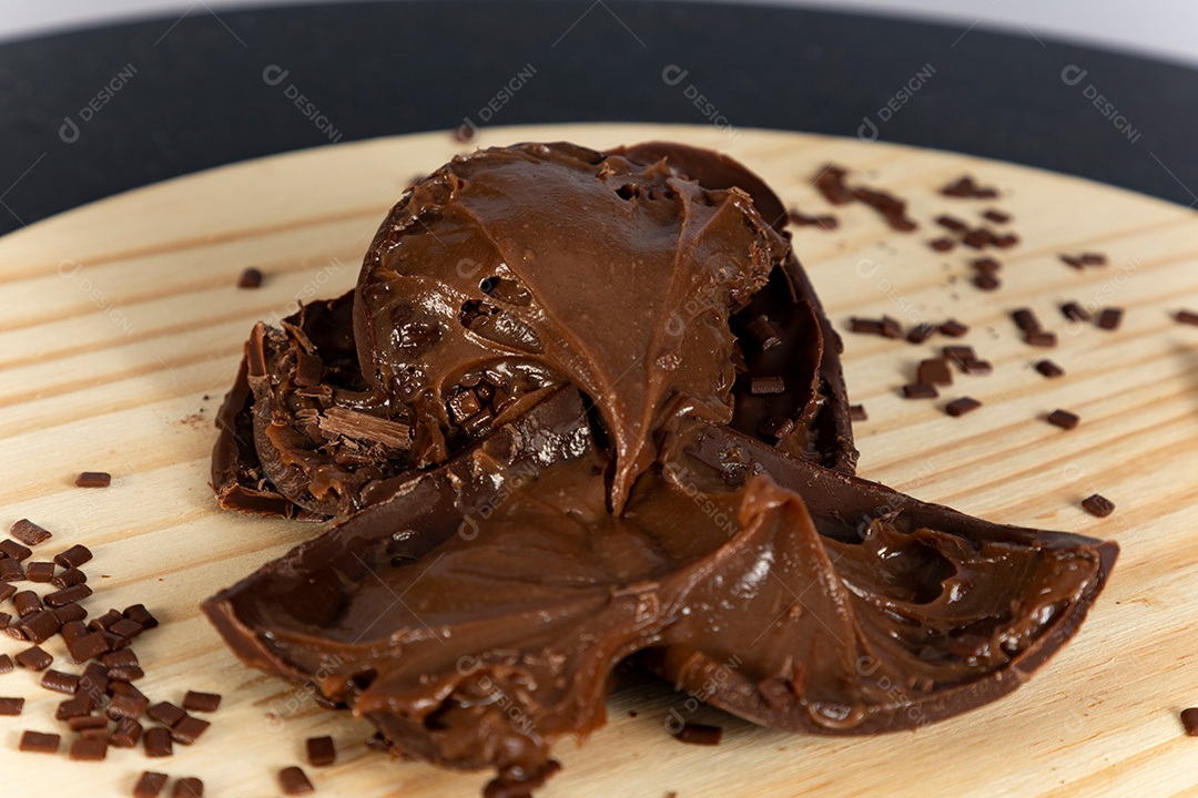 Ovo da páscoa partido ao meio sobre mesa madeira