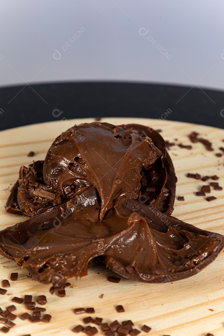 Ovo da páscoa partido ao meio sobre mesa madeira