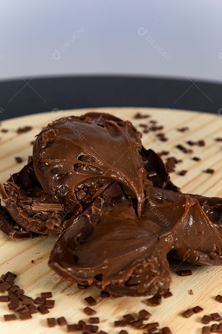 Ovo da páscoa partido ao meio sobre mesa madeira