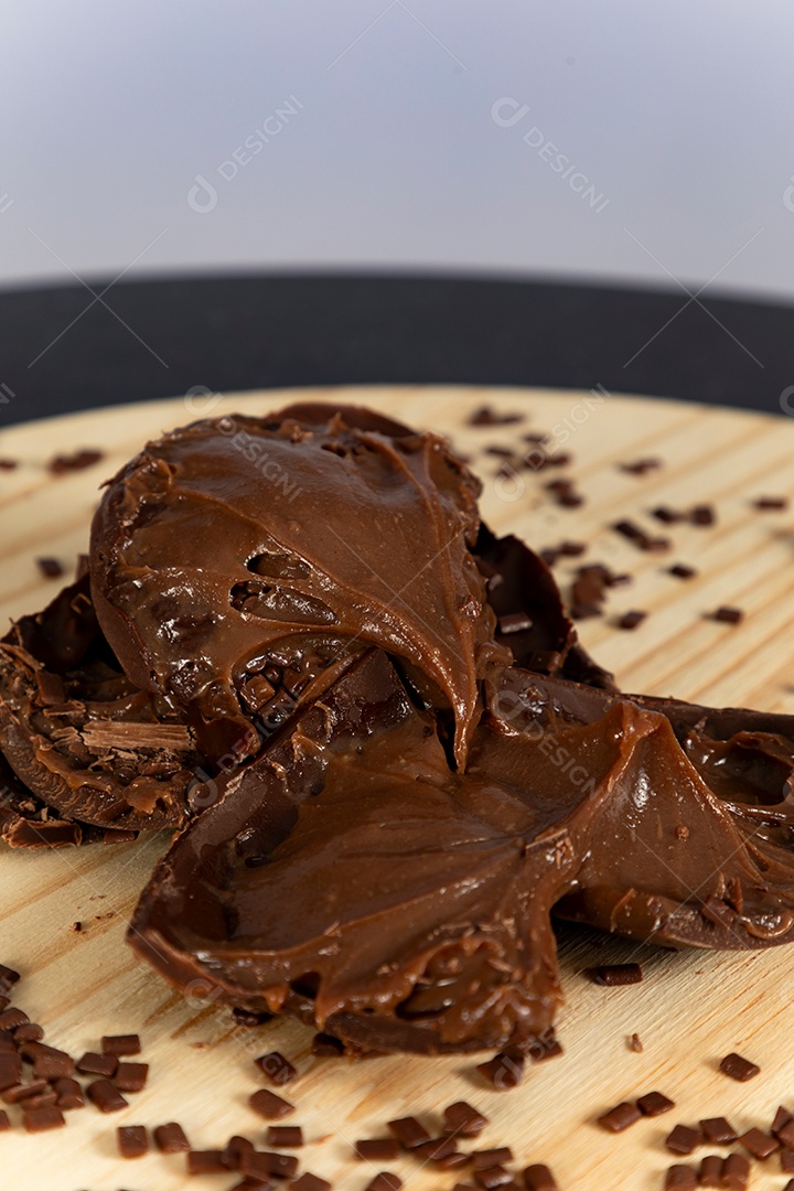 Ovo da páscoa partido ao meio sobre mesa madeira