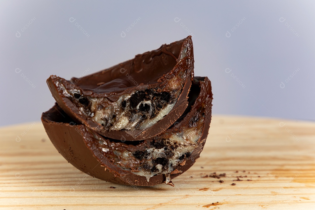 Ovo da páscoa partido ao meio sobre mesa madeira