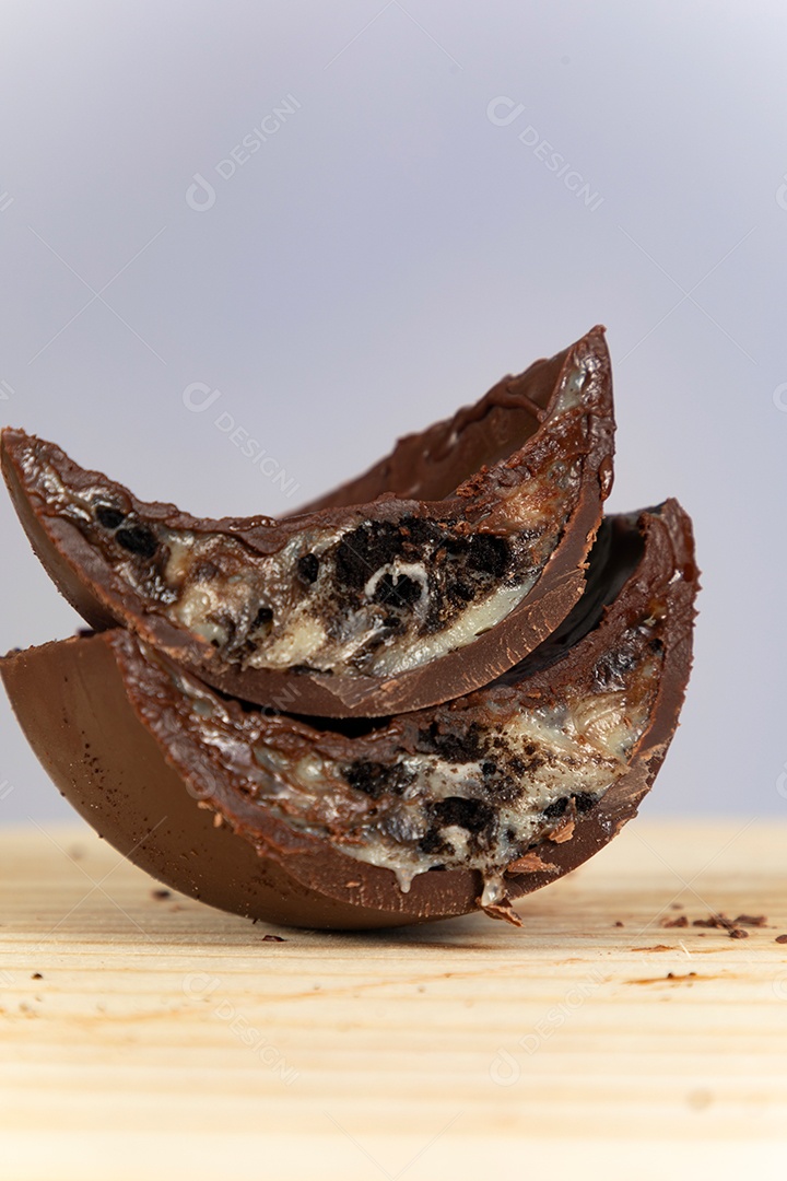 Ovo da páscoa partido ao meio sobre mesa madeira