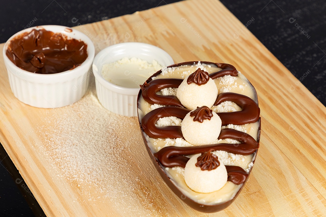 Delicioso ovo de páscoa sobre uma tábua de madeira