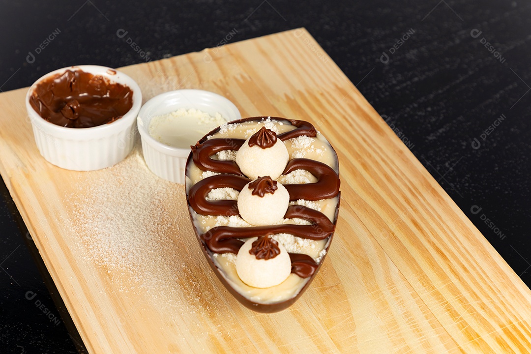 Delicioso ovo de páscoa sobre uma tábua de madeira