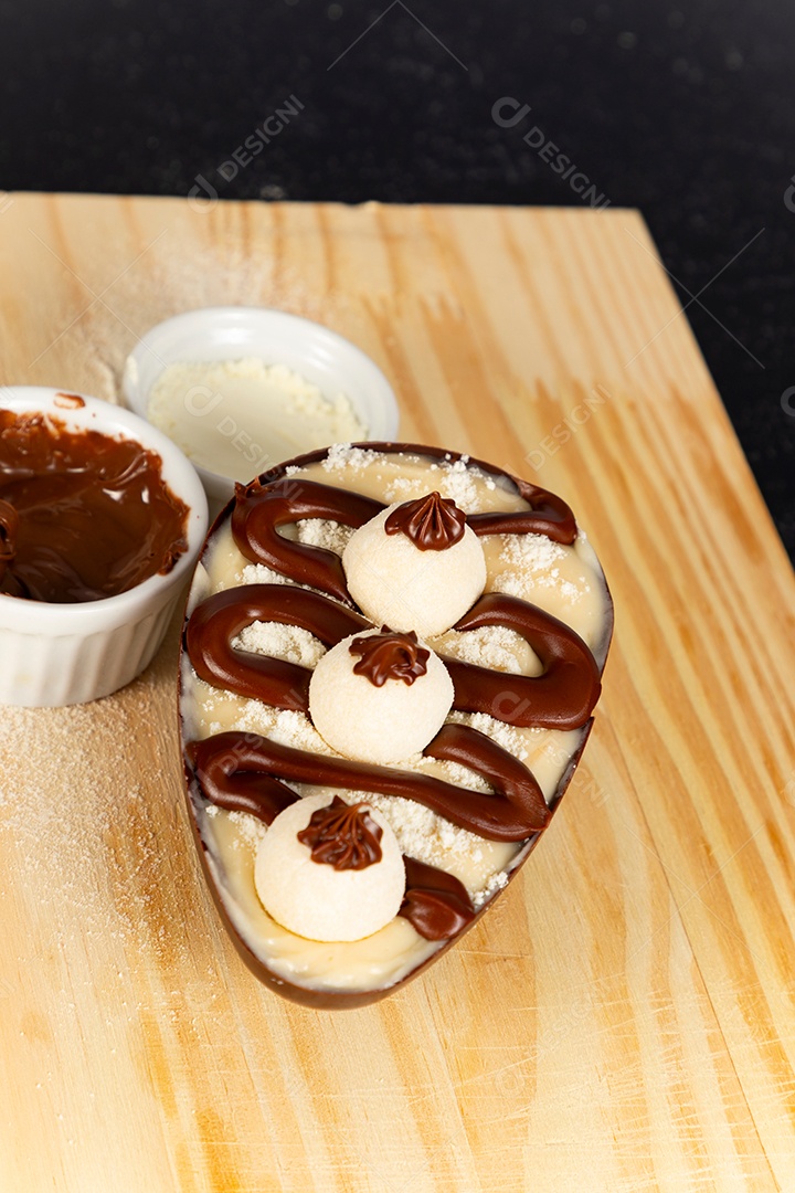 Delicioso ovo de páscoa sobre uma tábua de madeira