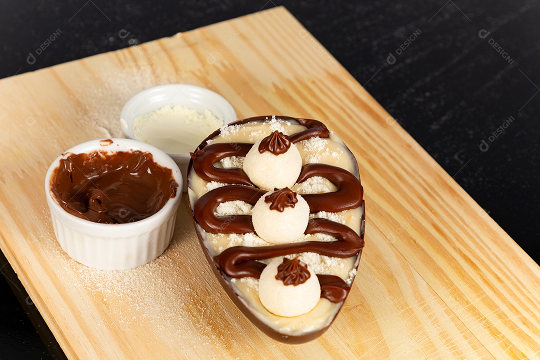 Delicioso ovo de páscoa sobre uma tábua de madeira