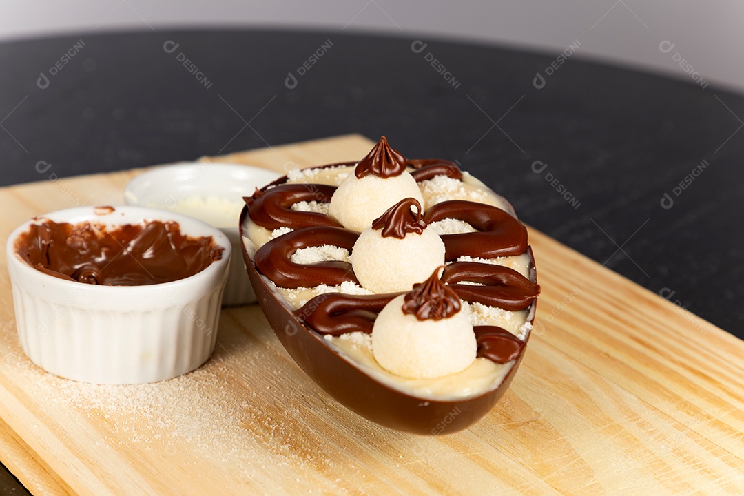 Delicioso ovo de páscoa sobre uma tábua de madeira