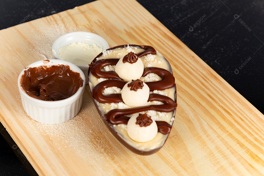 Delicioso ovo de páscoa sobre uma tábua de madeira