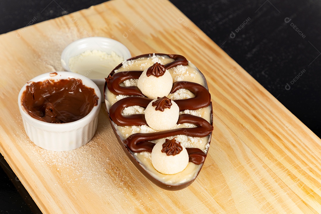 Delicioso ovo de páscoa sobre uma tábua de madeira