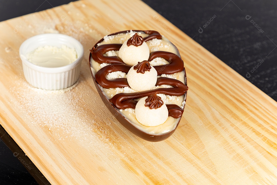 Delicioso ovo de páscoa sobre uma tábua de madeira