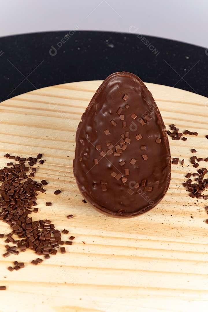 Delicioso ovo de páscoa sobre uma tábua de madeira