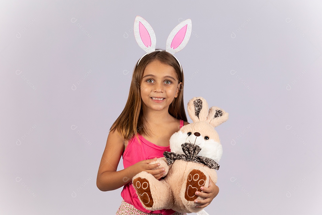 Linda garotinha usando tiara e segurando coelho de pelúcia celebrando páscoa