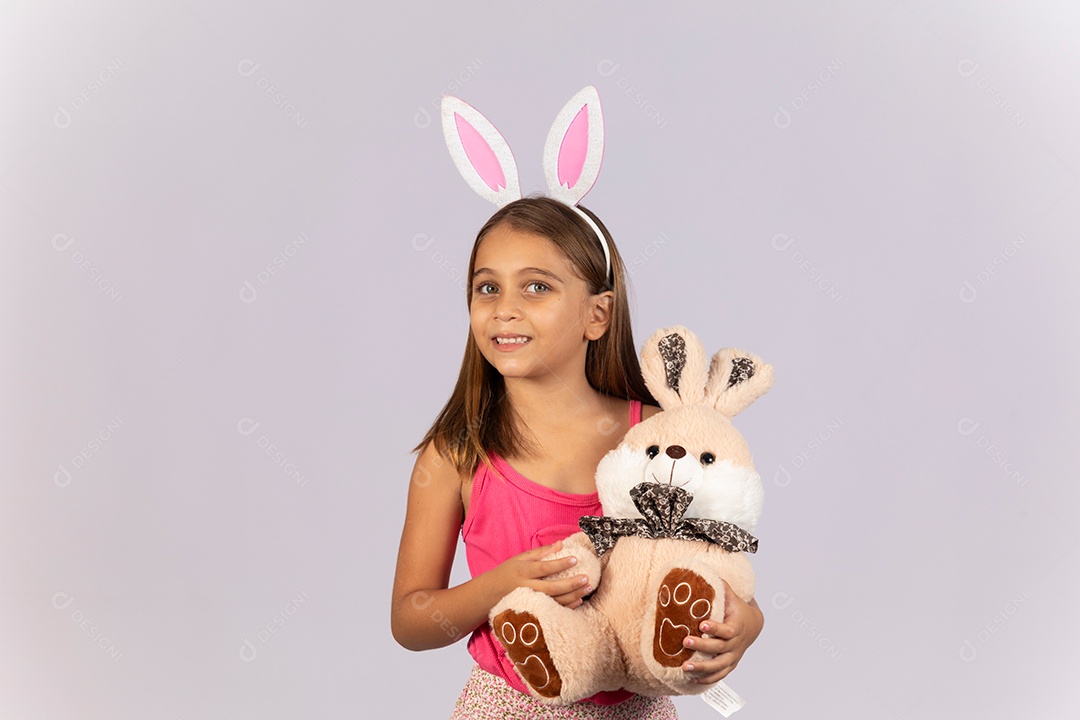 Linda garotinha usando tiara e coelho de pelúcia celebrando páscoa