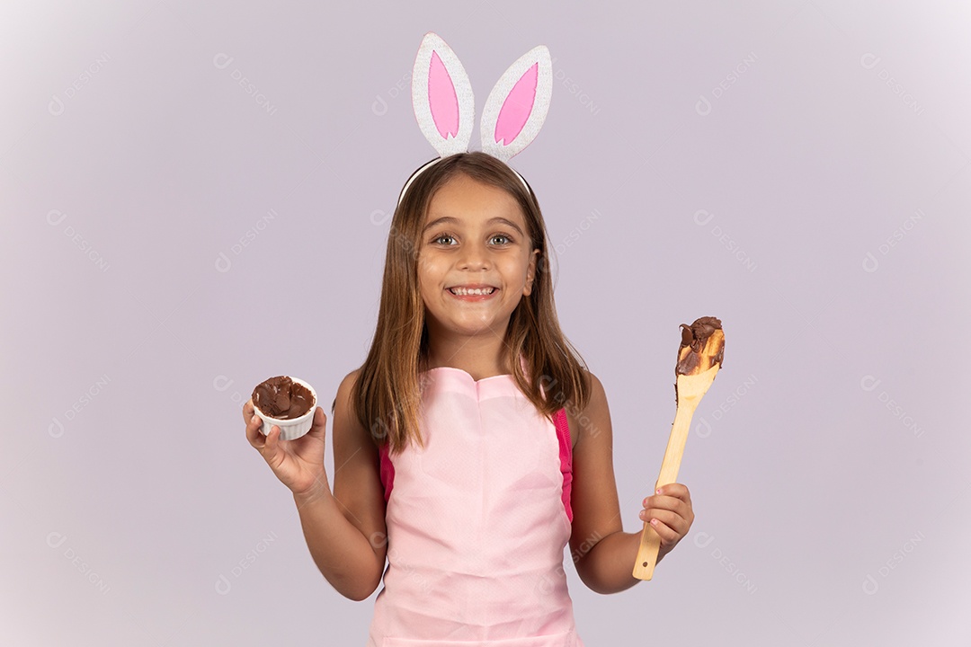 Linda garotinha comendo ovo de chocolate celebrando páscoa