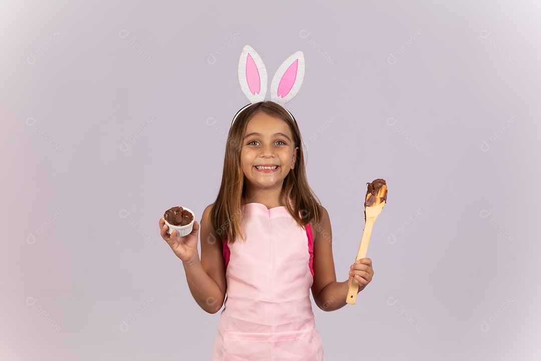 Linda garotinha comendo ovo de chocolate celebrando páscoa