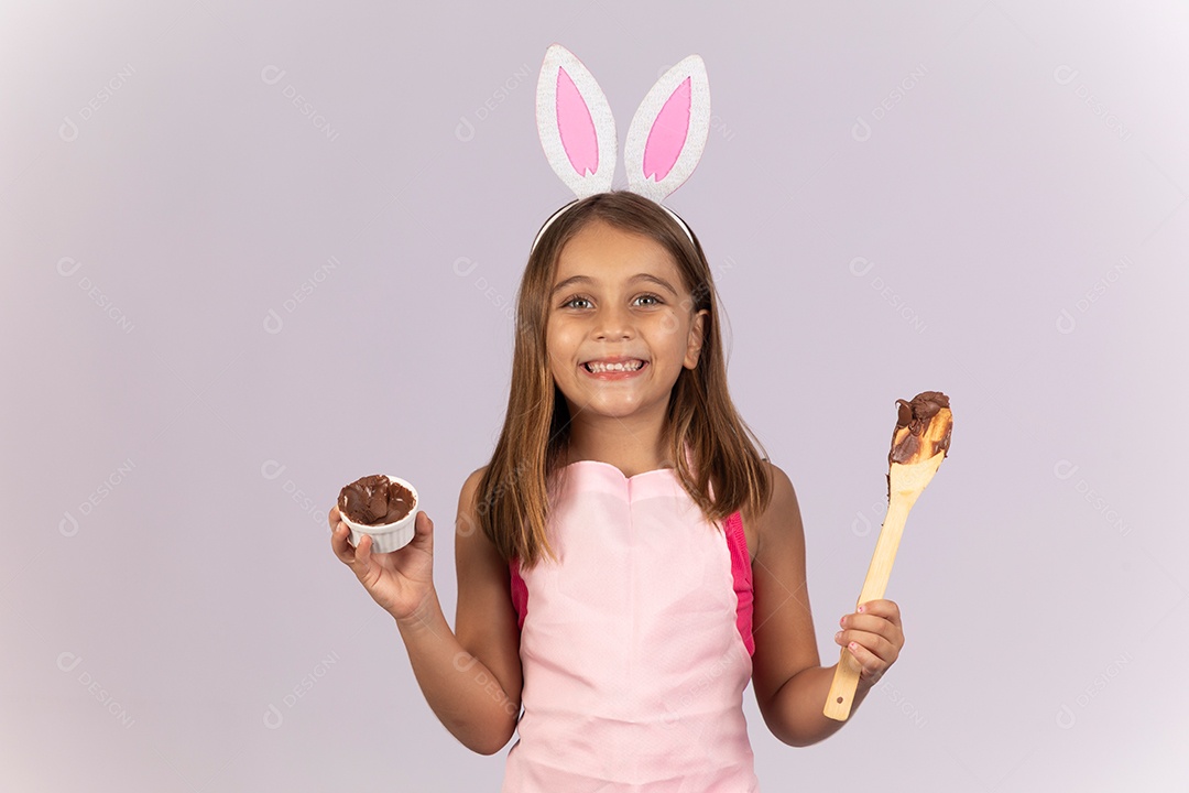 Linda garotinha comendo ovo de chocolate celebrando páscoa